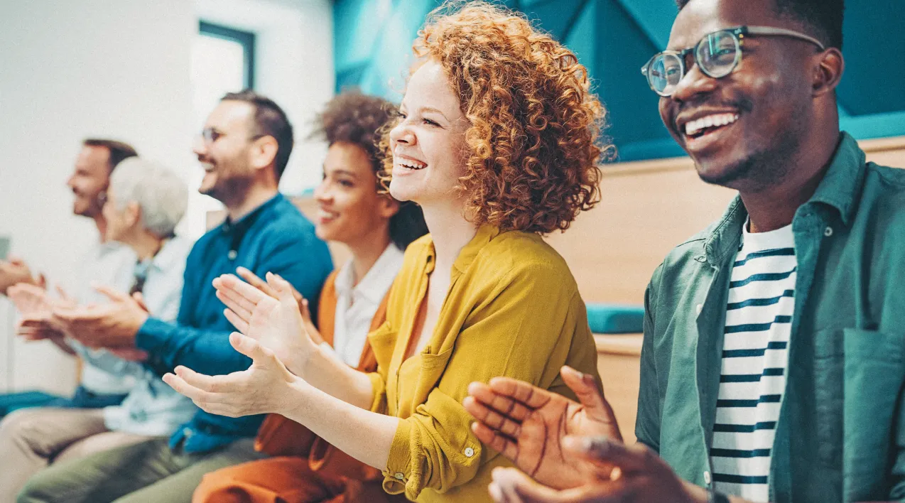 A row of smiling businesspeople clapping