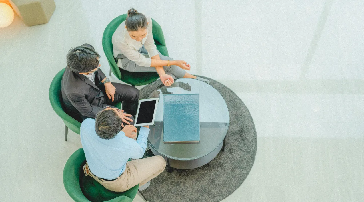 Three people sitting around a glass table