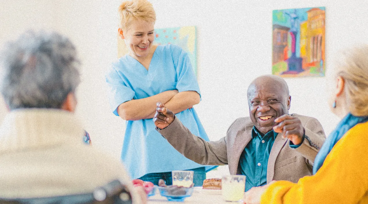 Older people smiling around a table