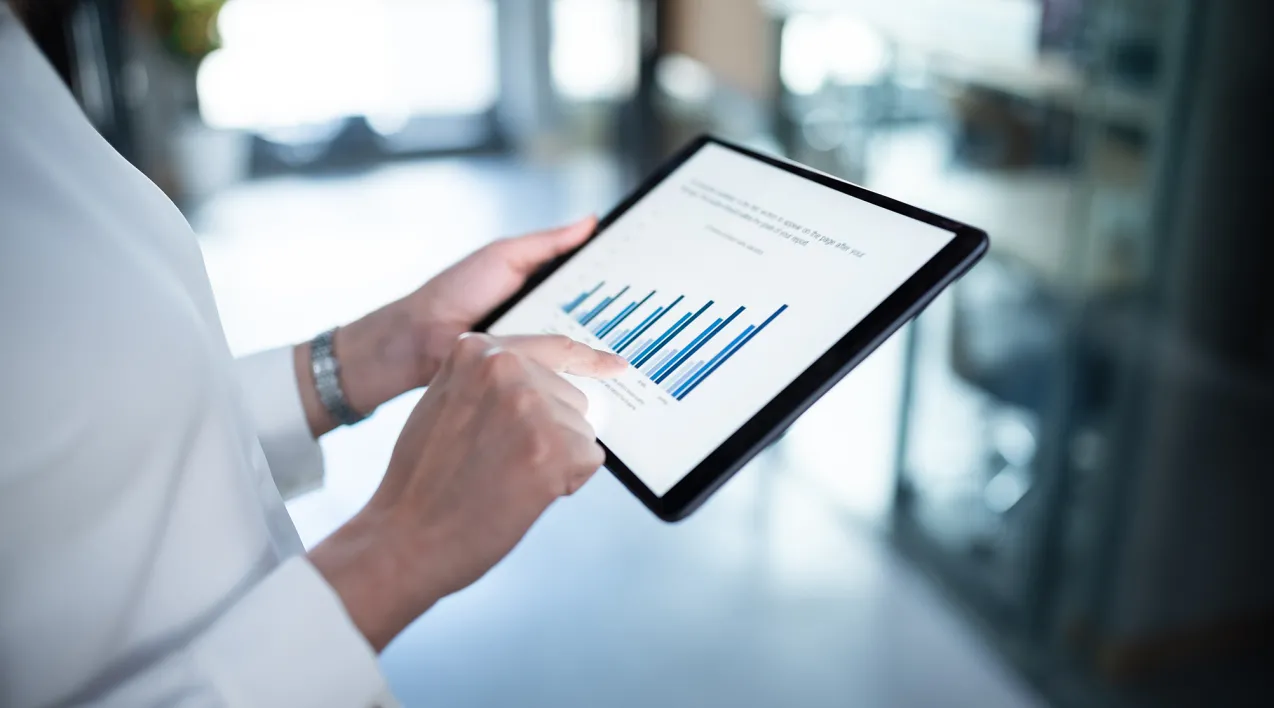 A woman uses a tablet to view a report.