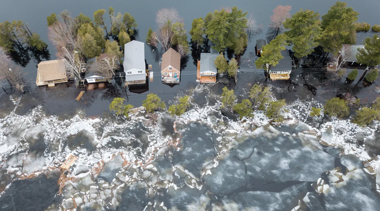 An overhead view of flood waters encroaching on homes.