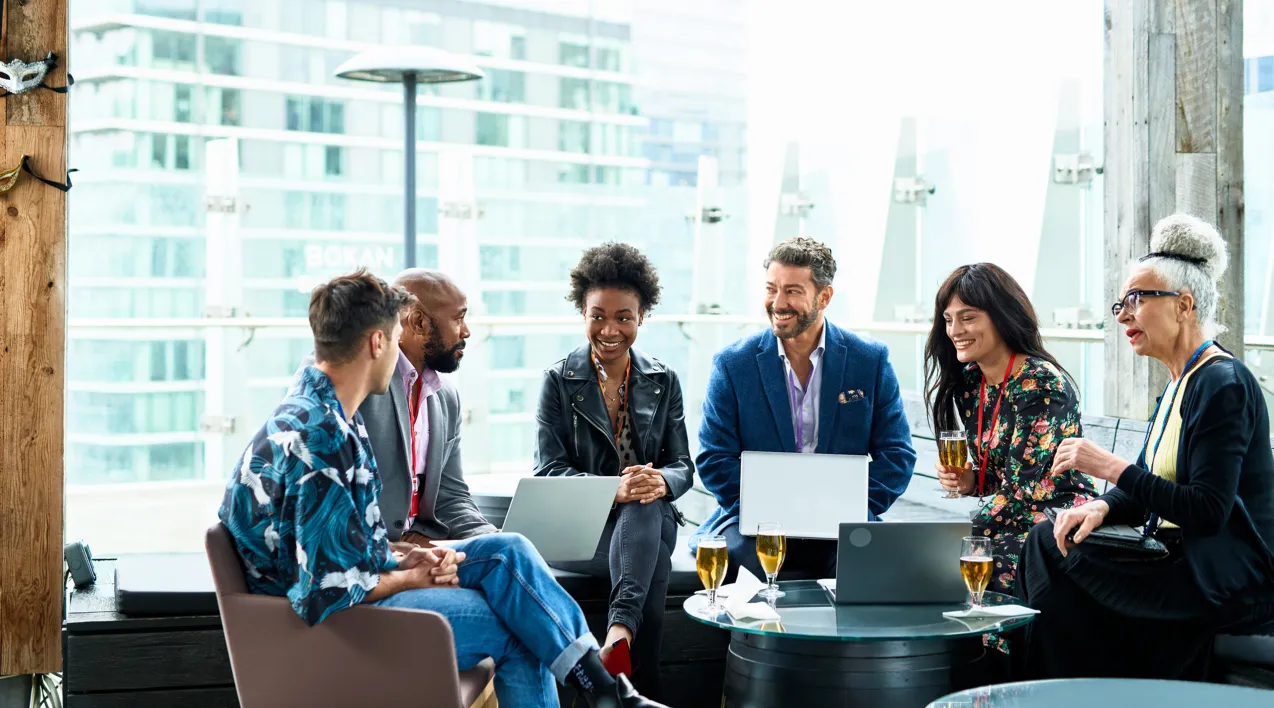 A group sits around a small table in discussion.