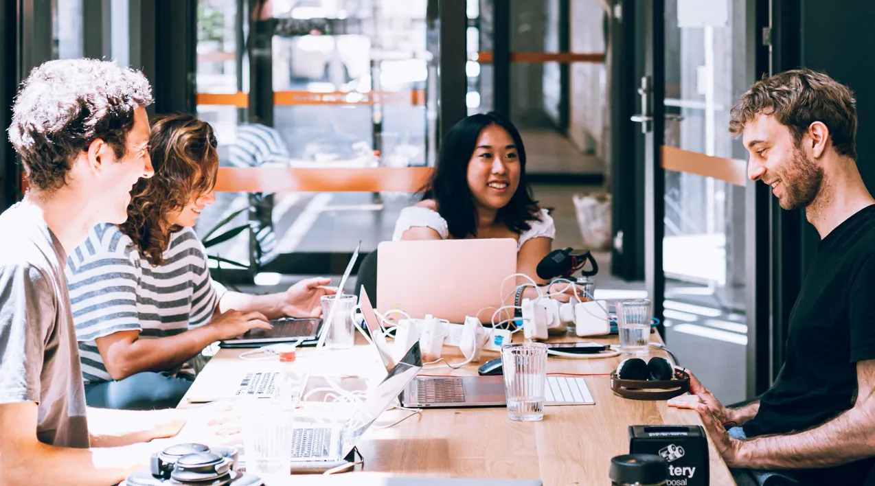 Workers sitting around a table collaborating on a project.