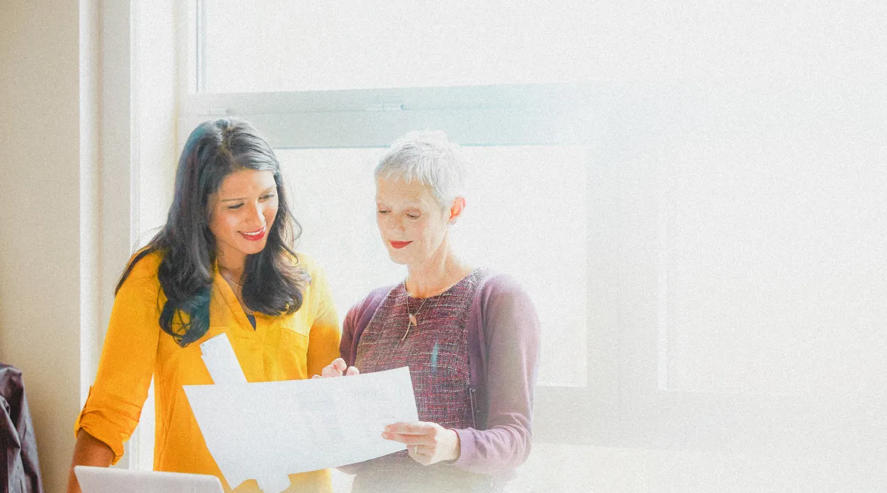 Two women looking at a paper