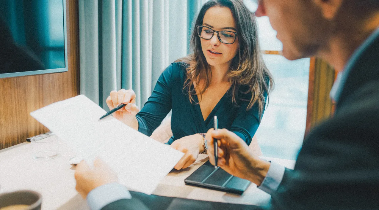 Woman in glasses pointing to a paper