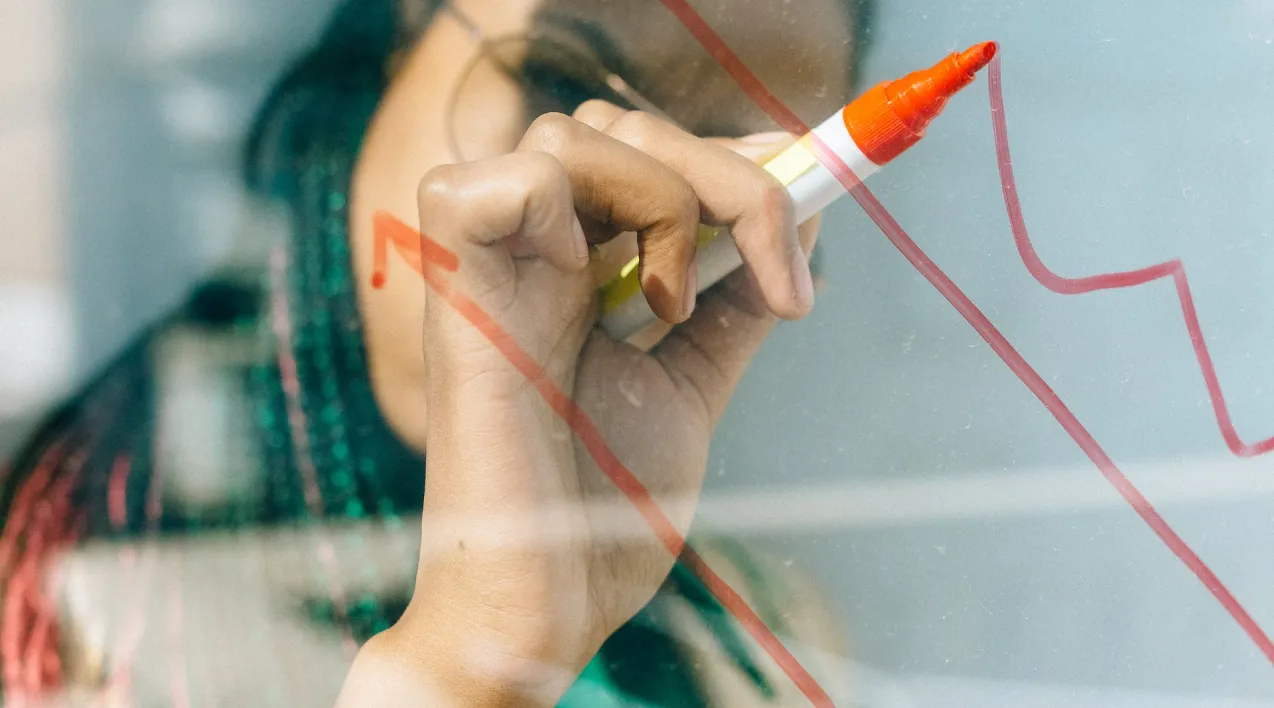 Person drawing graph line on glass